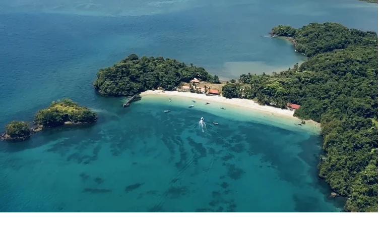Aerial view of clear turquoise water, reefs and islets in Coiba National Park on a calm green-season morning